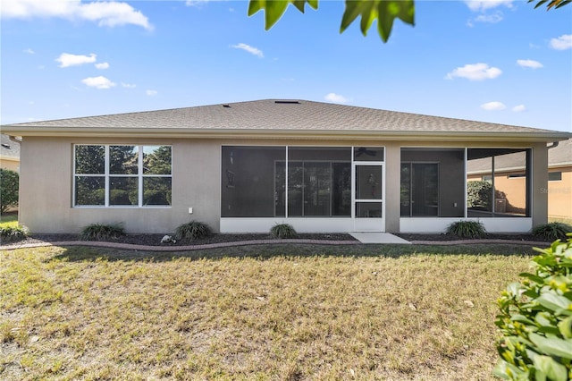 rear view of house with a sunroom and a yard