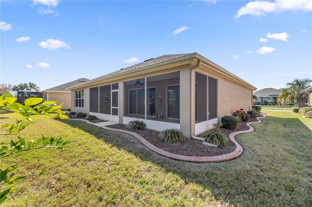 rear view of house featuring a sunroom and a yard