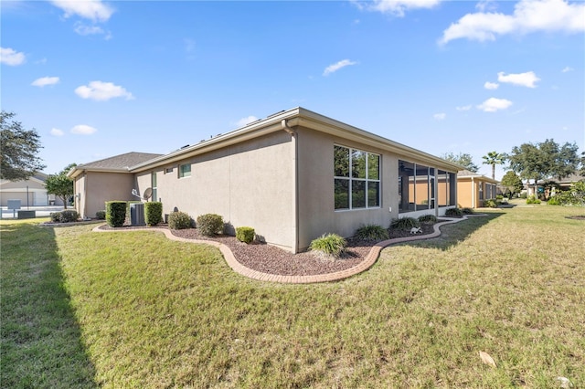 view of property exterior featuring central AC unit and a lawn