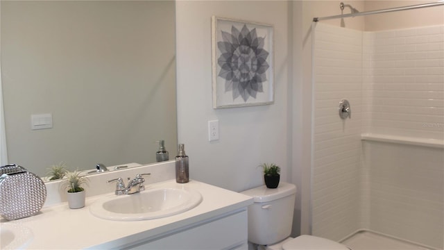 bathroom featuring a shower, vanity, and toilet