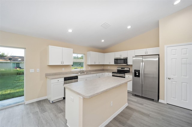 kitchen with white cabinets, sink, a kitchen island, and appliances with stainless steel finishes