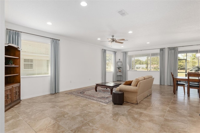 living room with ceiling fan and crown molding