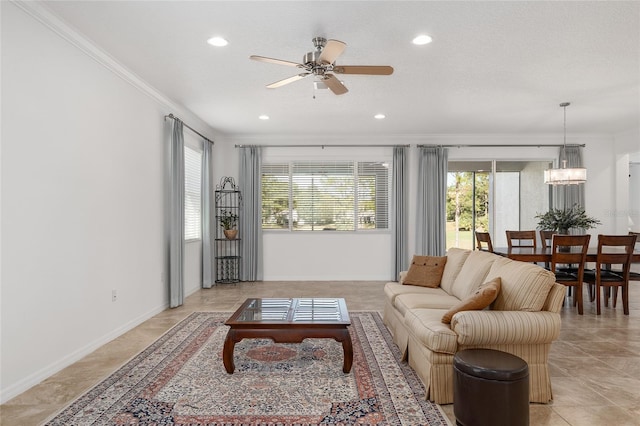 living room with ceiling fan with notable chandelier, ornamental molding, and a textured ceiling