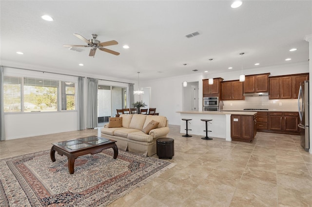 living room with ceiling fan, ornamental molding, and sink