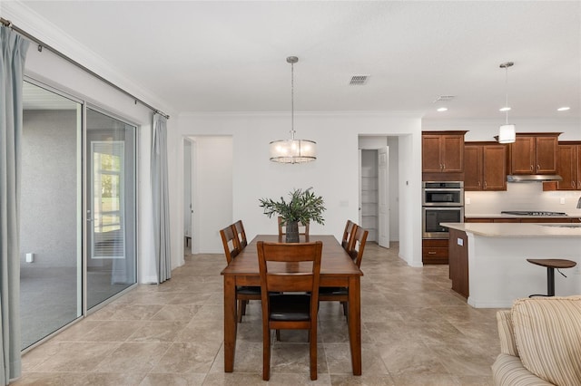 dining space with ornamental molding and a notable chandelier