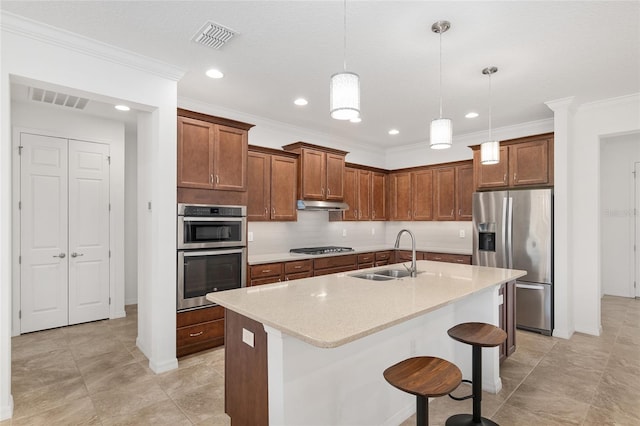 kitchen with sink, stainless steel appliances, a kitchen breakfast bar, an island with sink, and pendant lighting