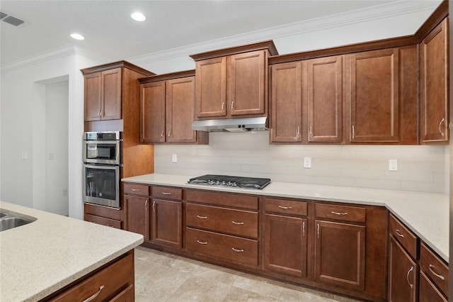 kitchen with light tile patterned floors, crown molding, appliances with stainless steel finishes, and tasteful backsplash