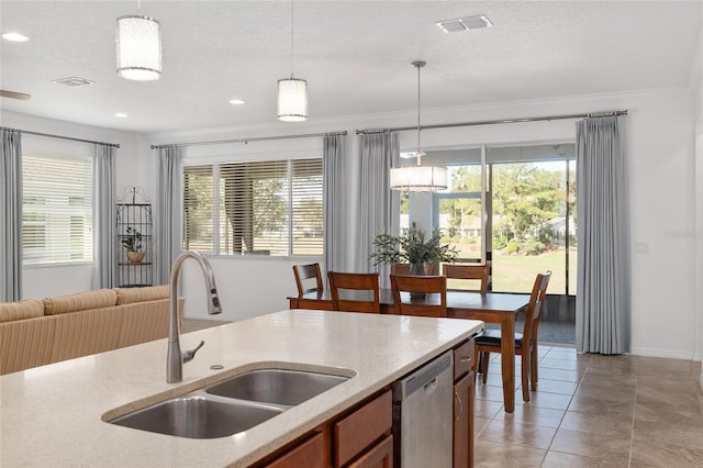 kitchen featuring crown molding, sink, pendant lighting, and a textured ceiling