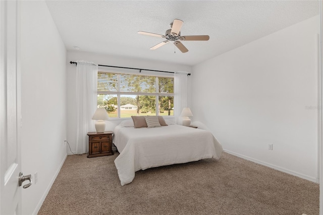 bedroom featuring ceiling fan, light colored carpet, and a textured ceiling