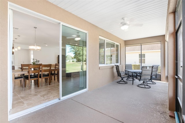 sunroom with ceiling fan and wooden ceiling