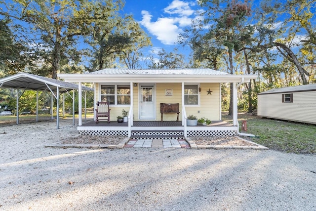 view of front of property featuring a storage shed, covered porch, and a carport