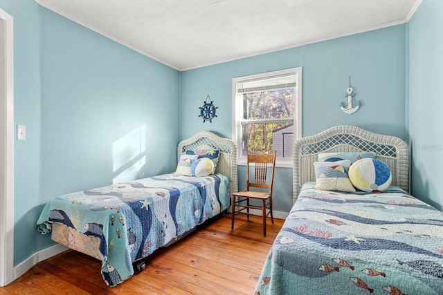 bedroom featuring wood-type flooring and ornamental molding