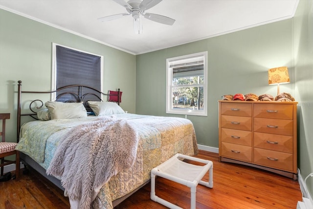 bedroom featuring ceiling fan, crown molding, and wood-type flooring