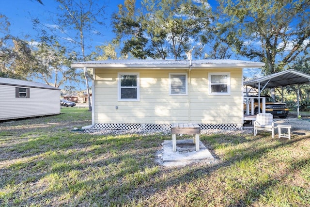 rear view of house featuring a yard and a carport