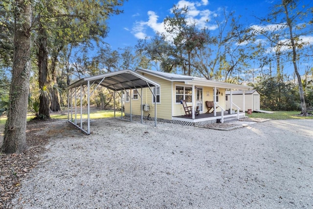 view of front of house featuring a carport, covered porch, and a storage shed