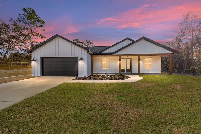 view of front of home with a garage and a lawn