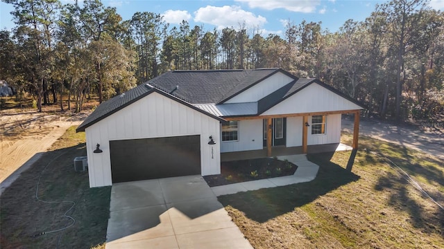 view of front of house featuring central AC, a garage, covered porch, and a front lawn