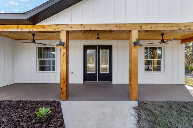 view of exterior entry with ceiling fan and covered porch