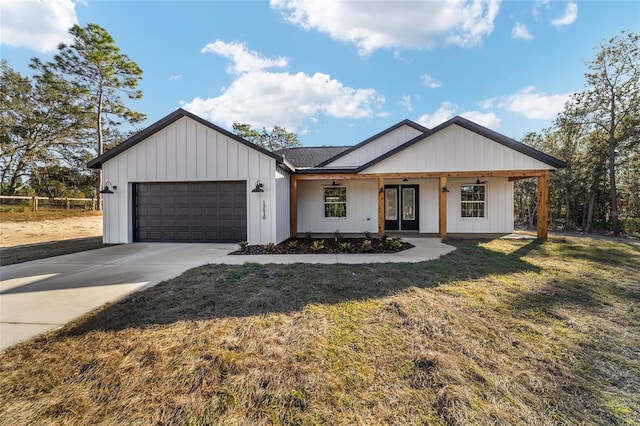 modern inspired farmhouse with a front yard and a garage