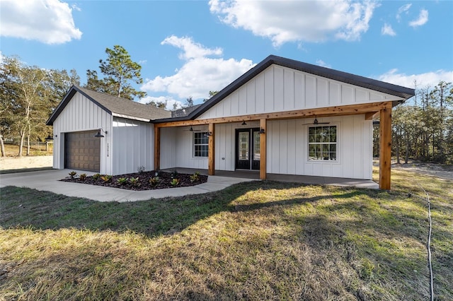 view of front of property with a front yard, a garage, and covered porch