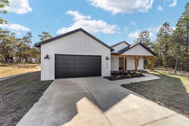 modern inspired farmhouse featuring covered porch, a garage, and a front lawn