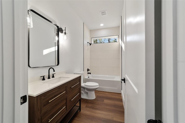 full bathroom with hardwood / wood-style floors, vanity, toilet, and tiled shower / bath