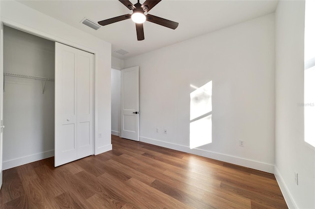 unfurnished bedroom with ceiling fan, dark hardwood / wood-style flooring, and a closet