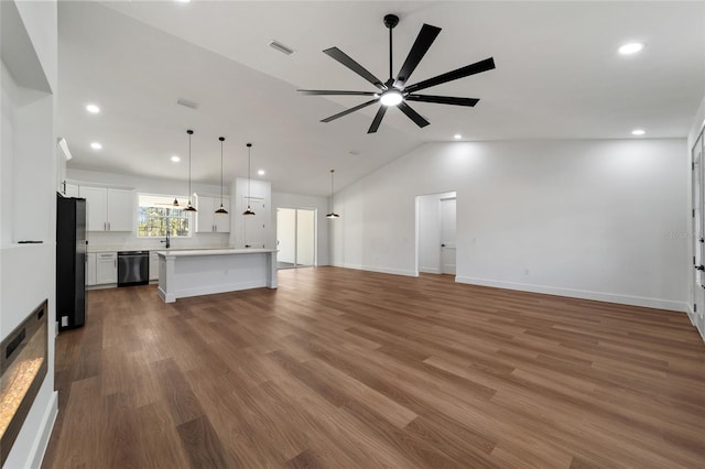 unfurnished living room featuring hardwood / wood-style flooring, vaulted ceiling, and ceiling fan