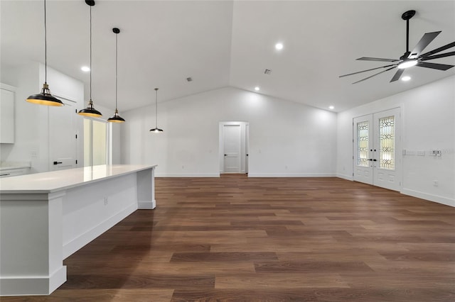 unfurnished living room with ceiling fan, dark hardwood / wood-style flooring, french doors, and vaulted ceiling