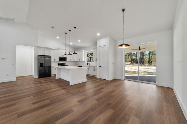 kitchen featuring pendant lighting, a center island, stainless steel appliances, and white cabinetry