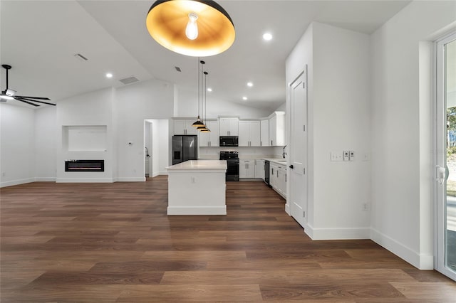 kitchen with black appliances, white cabinets, vaulted ceiling, dark hardwood / wood-style floors, and a kitchen island