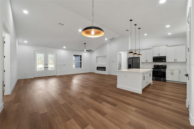 kitchen featuring a center island, hanging light fixtures, stainless steel appliances, white cabinets, and hardwood / wood-style flooring