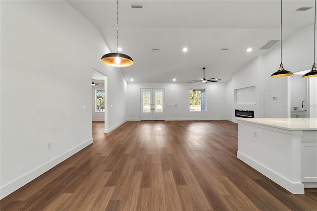 unfurnished living room with ceiling fan, french doors, high vaulted ceiling, and dark wood-type flooring