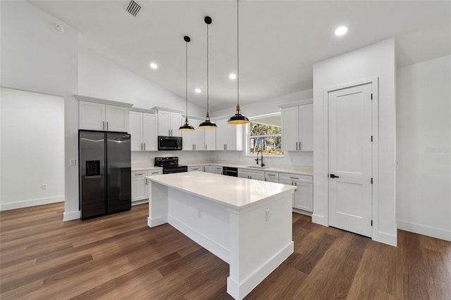 kitchen with sink, black appliances, pendant lighting, white cabinets, and a kitchen island