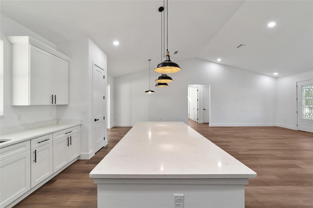 kitchen featuring white cabinets, a center island, lofted ceiling, and hanging light fixtures