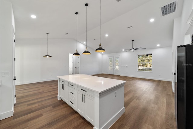 kitchen featuring lofted ceiling, ceiling fan, white cabinetry, and hanging light fixtures