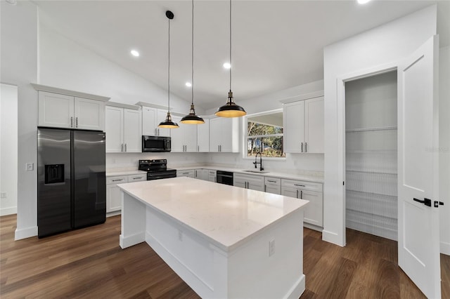 kitchen featuring white cabinetry, sink, hanging light fixtures, a kitchen island, and black appliances