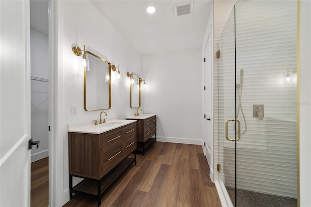 bathroom featuring hardwood / wood-style floors, vanity, and a shower with shower door