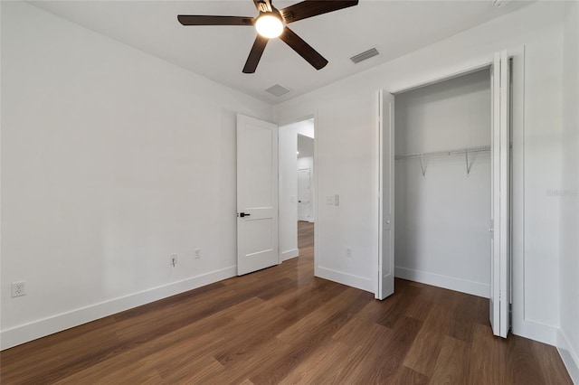 unfurnished bedroom with ceiling fan, a closet, and dark hardwood / wood-style floors