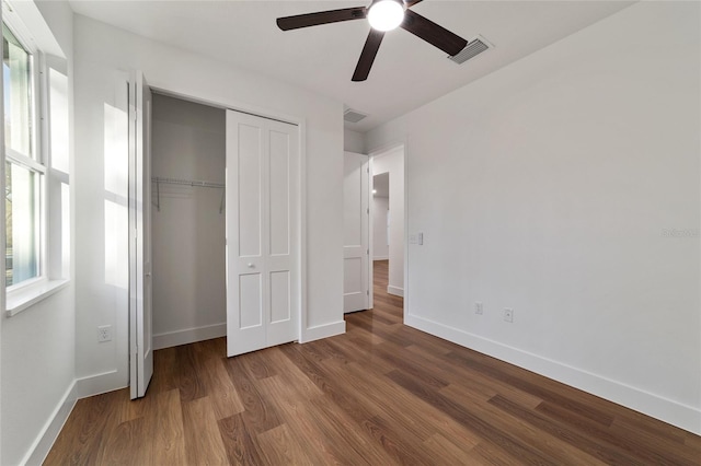 unfurnished bedroom featuring ceiling fan, a closet, and wood-type flooring