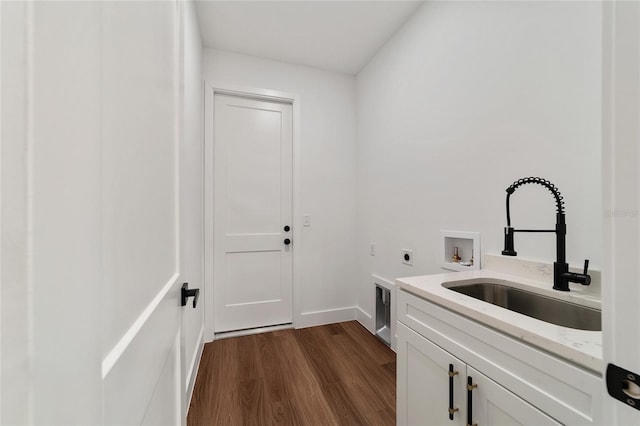 clothes washing area with hookup for an electric dryer, hookup for a washing machine, cabinets, sink, and hardwood / wood-style floors