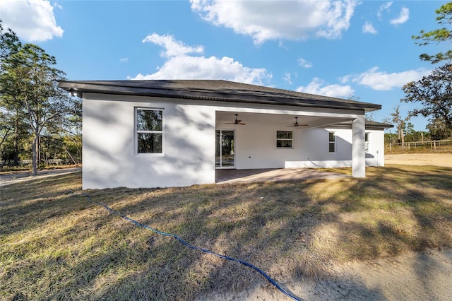 back of property with a patio, ceiling fan, and a lawn