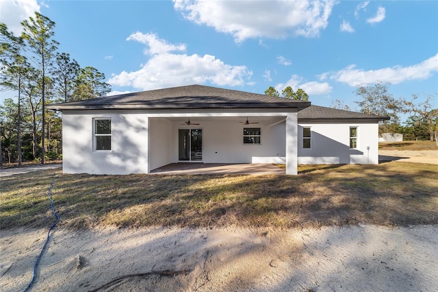 back of property with a lawn, a patio area, and ceiling fan