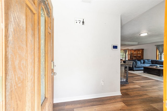 hall with dark wood-type flooring and a textured ceiling