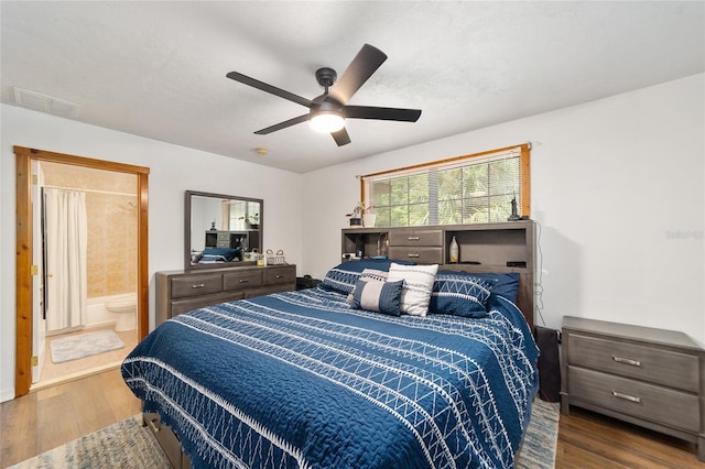 bedroom featuring hardwood / wood-style floors, ensuite bath, and ceiling fan