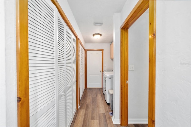 hallway with hardwood / wood-style floors and washer and clothes dryer