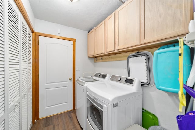 laundry area featuring washer and clothes dryer, dark hardwood / wood-style floors, cabinets, and a textured ceiling