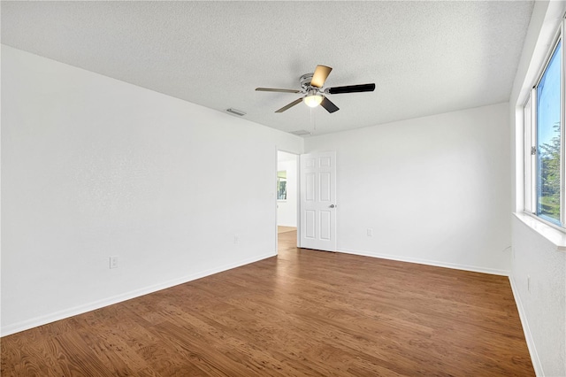 unfurnished room featuring ceiling fan, dark hardwood / wood-style flooring, and a textured ceiling