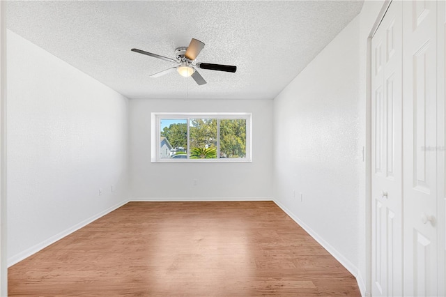 empty room featuring ceiling fan, a textured ceiling, and light hardwood / wood-style flooring