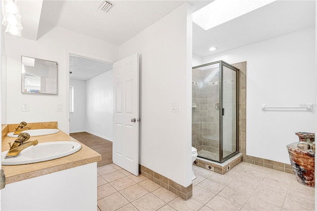 bathroom with toilet, a textured ceiling, tile patterned floors, and an enclosed shower